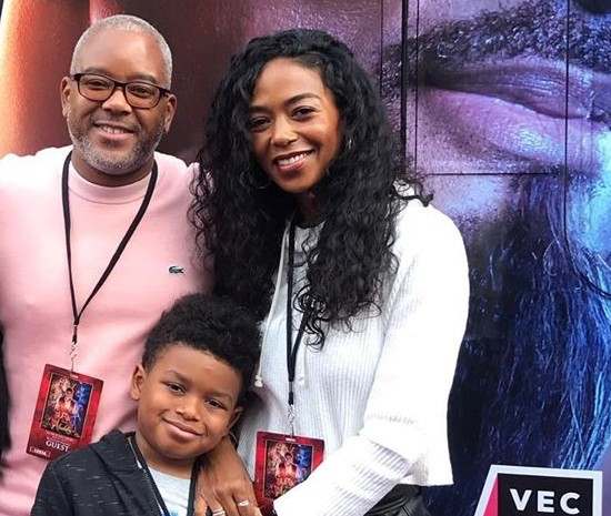 Ananda Lewis looking happy with her husband and son